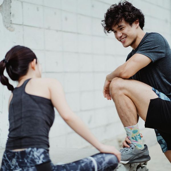 Man smiling and stretching outdoors in a park, feeling energized and positive.